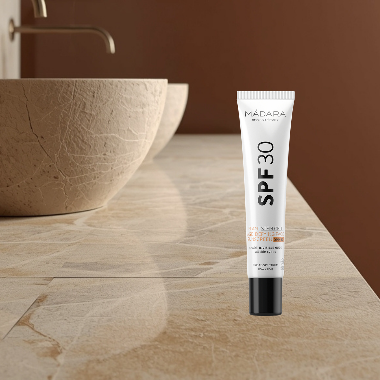 Mádara SPF30 stem cell skincare tube on a bathroom counter with a neutral background