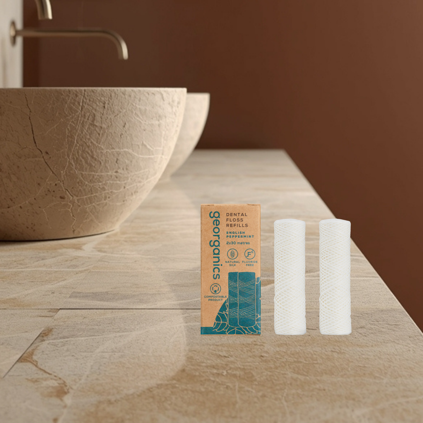 Two Georganics dental floss refills and their packaging on a bathroom counter.
