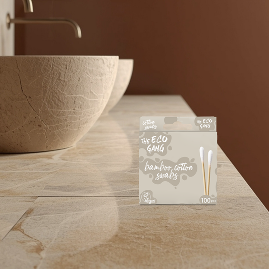 Pack of bamboo cotton swabs from The Eco Gang on a bathroom counter with a stone sink.