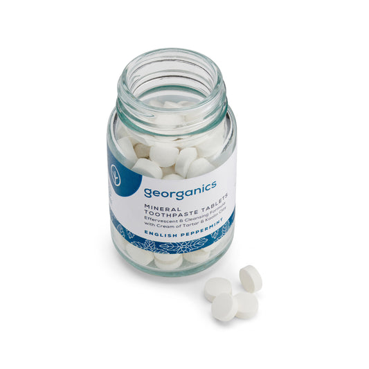 Glass jar of georganics english peppermint mineral toothpaste tablets on a white background
