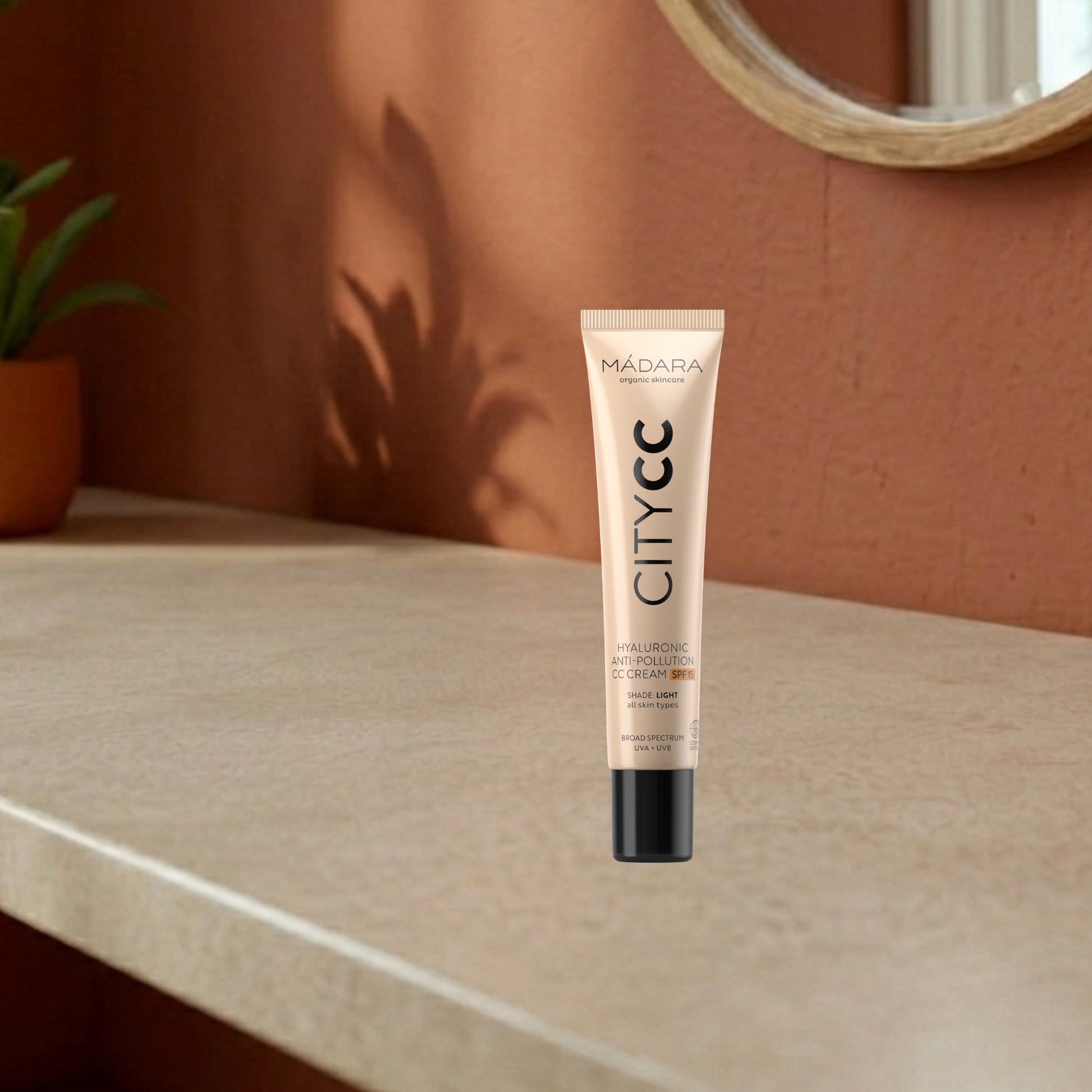CityCC CC cream tube light on a countertop with a warm-toned wall and plant in the background