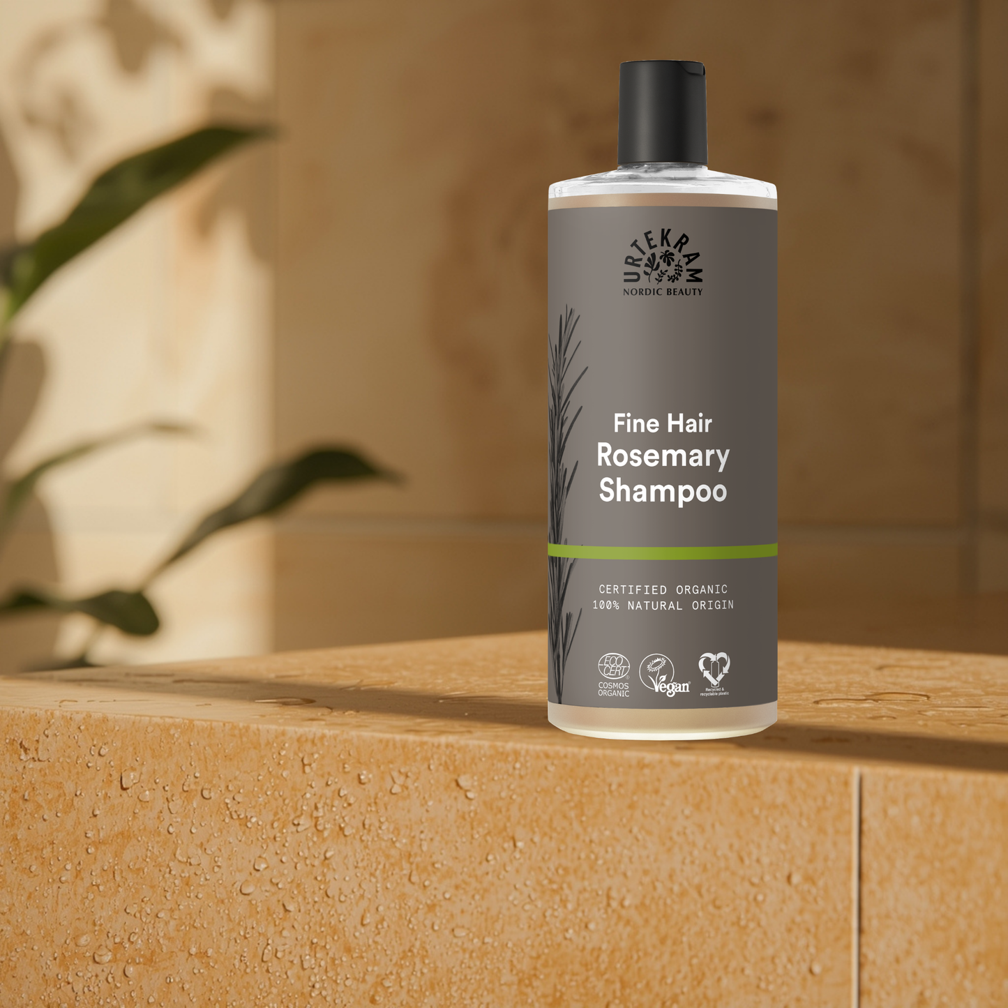 Bottle of Urtekram Rosemary Shampoo on a wooden surface with a blurred background