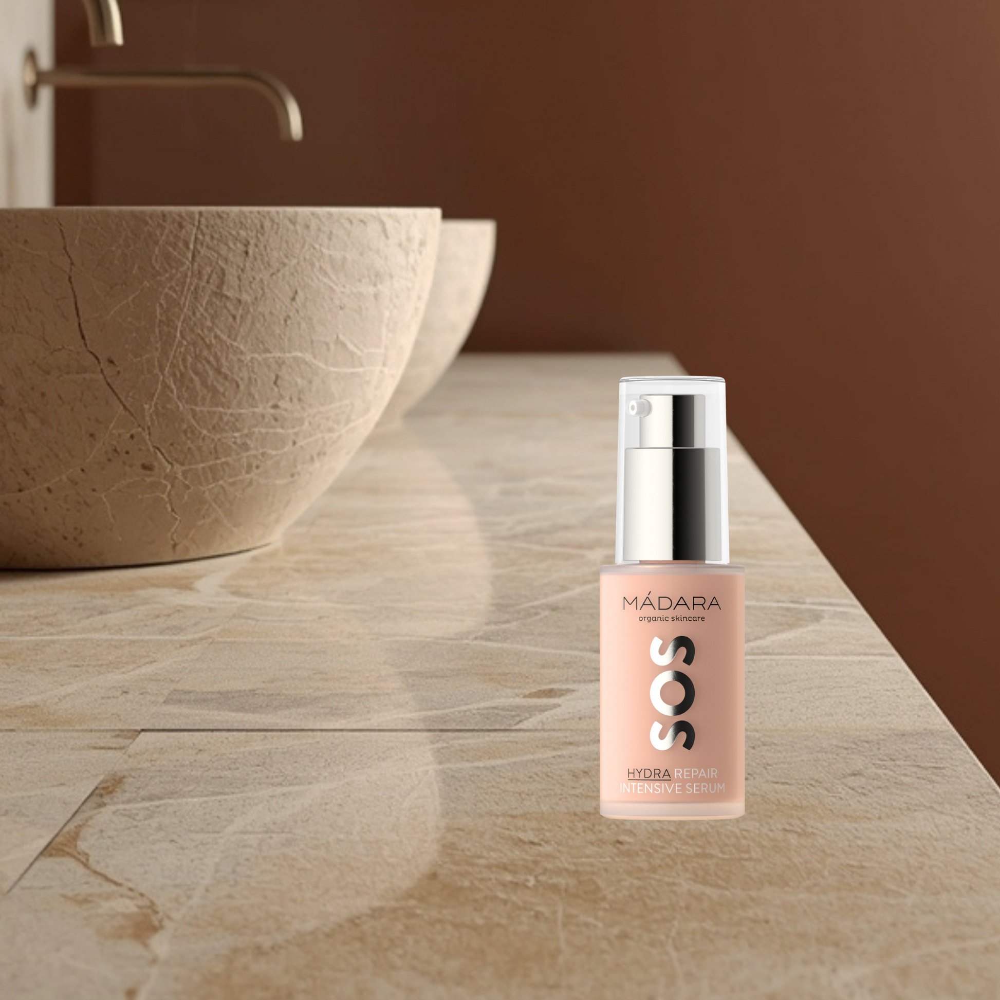 Skincare serum bottle labeled 'SOS Hydra Repair Intensive Serum' by Mádara on a bathroom counter.