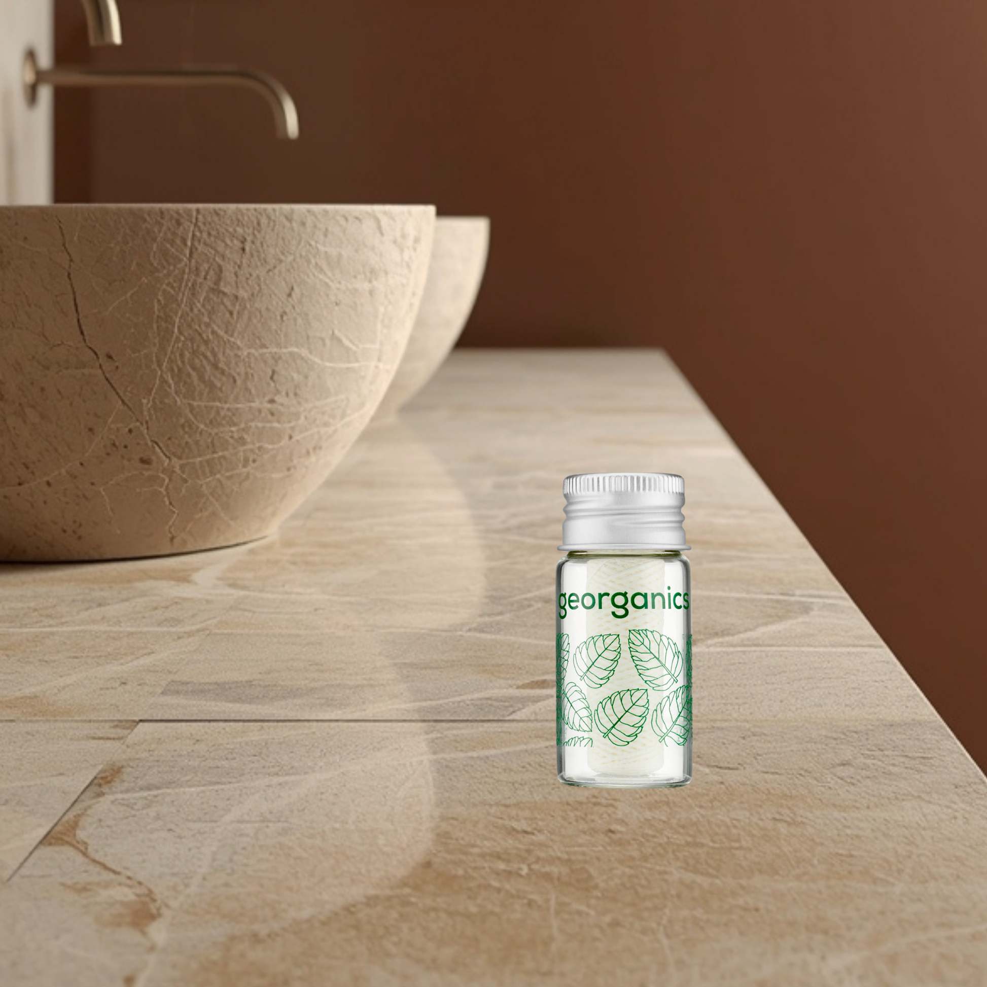 Georganics silk dental floss in a glass bottle on a wooden surface with a brown background