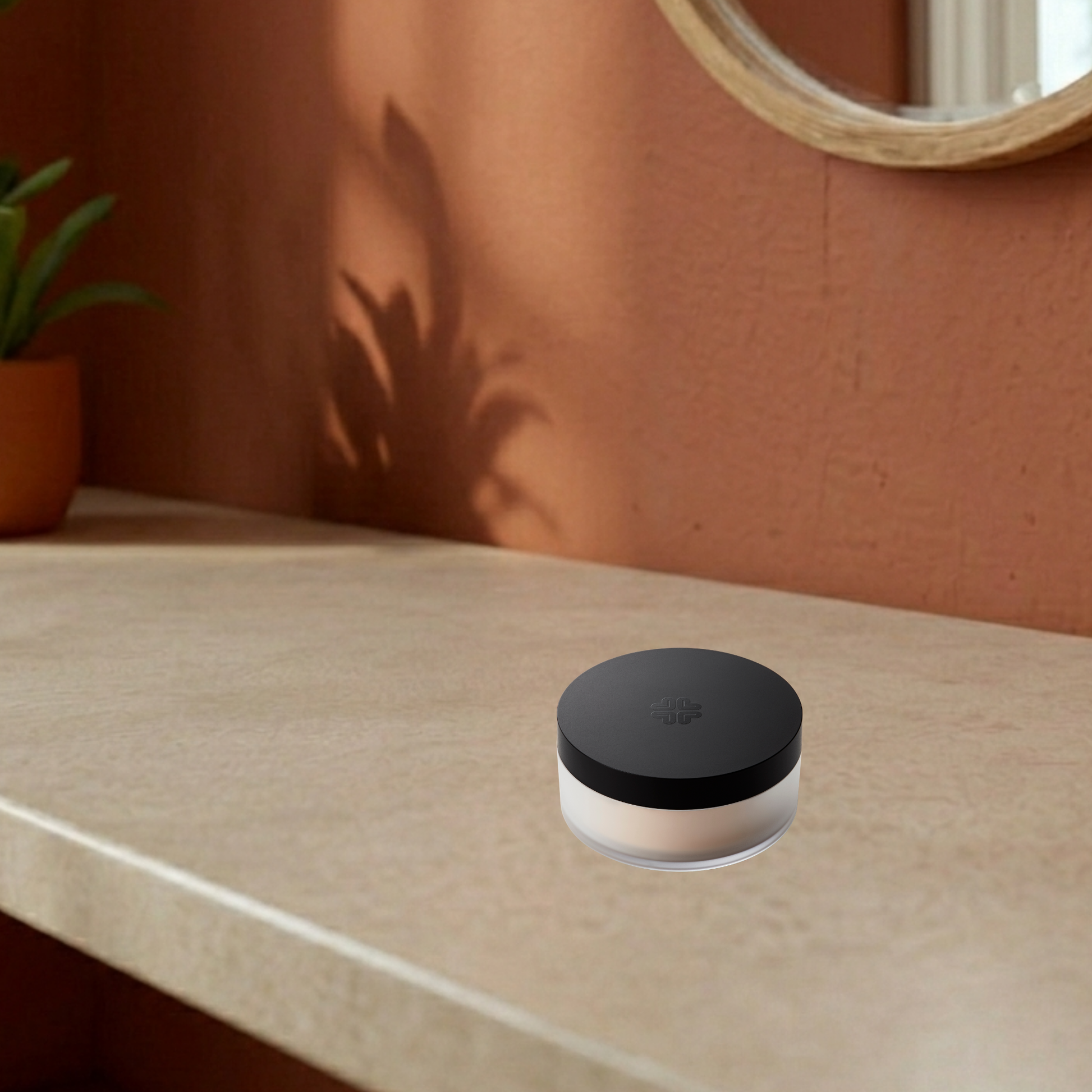 Lily Lolo mineral foundation SPF15 jar with black lid on a beige surface against an orange wall.