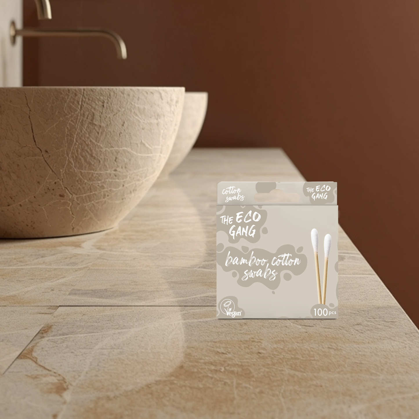 Pack of bamboo cotton swabs from The Eco Gang on a bathroom counter with a stone sink.