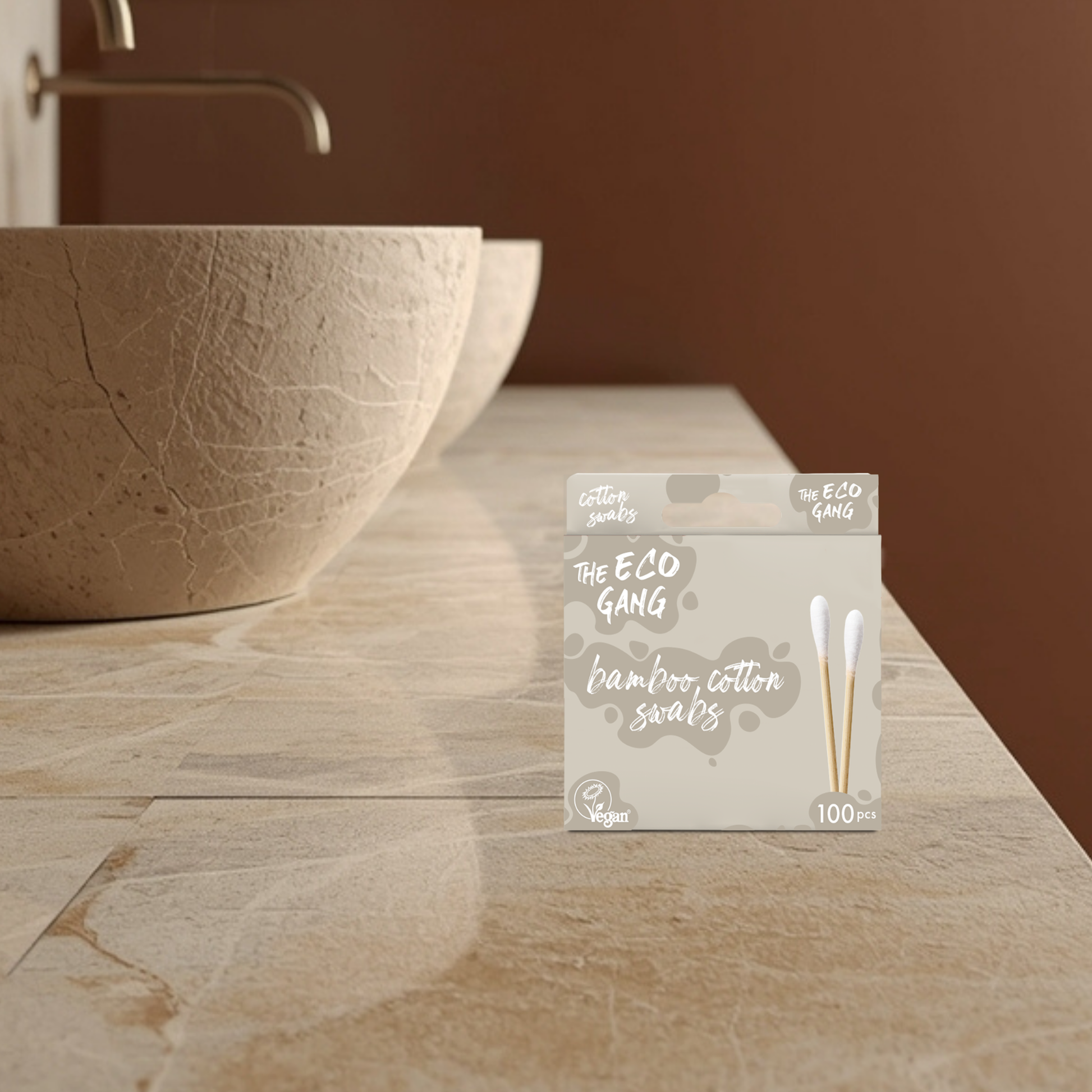 Pack of bamboo cotton swabs from The Eco Gang on a bathroom counter with a stone sink.