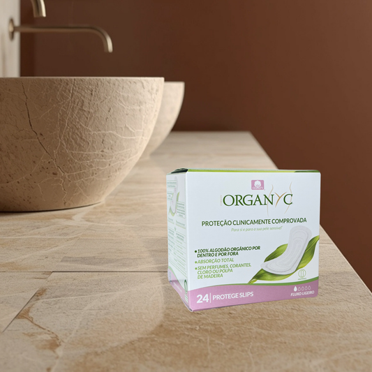 Box of Organyc folded panty liners on a bathroom counter with a brown bowl in the background.