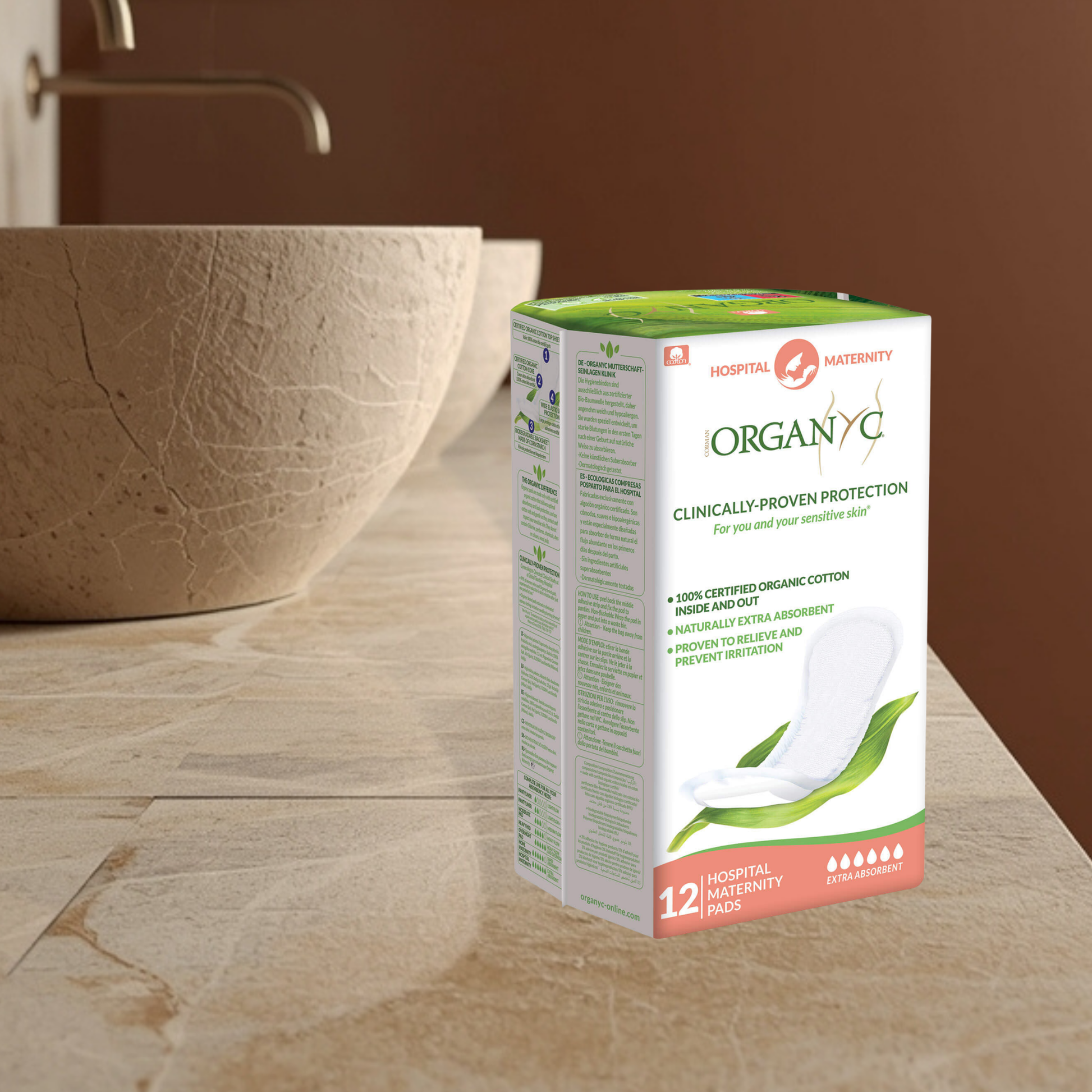 Box of Organyc hospital postpartum pads on a bathroom counter with a sink in the background.