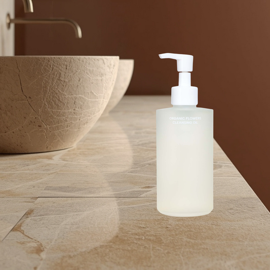 Whamisa organic flowers cleansing oil pump bottle on a bathroom counter with a brown sink and wall.