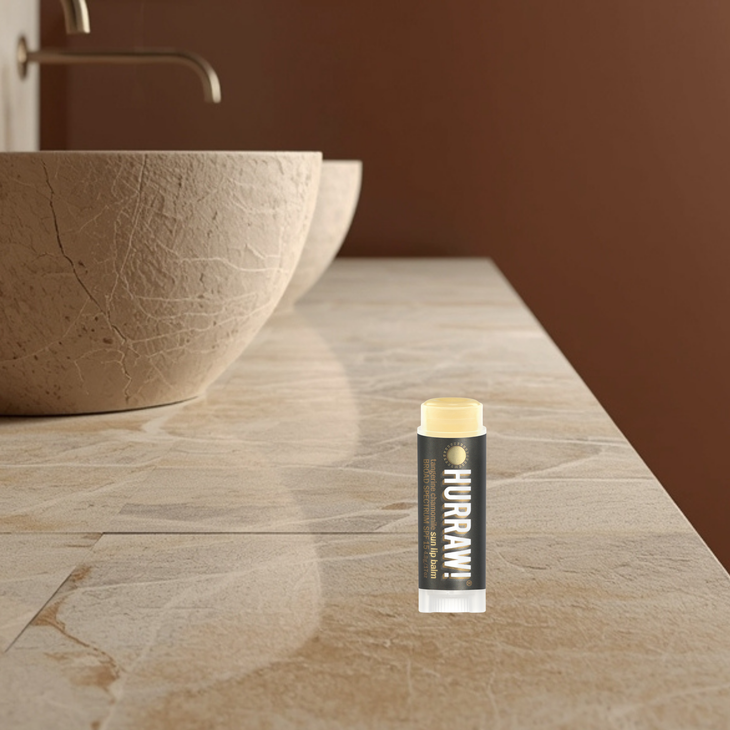 HURRRAW! sun lip balm on a bathroom counter with a sink in the background